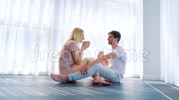 放大了坐在地板上喝早茶的年轻情侣视频的预览图