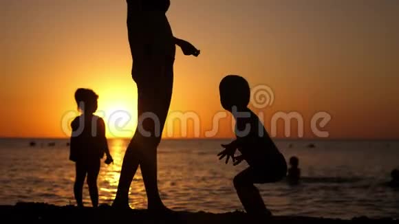 幸福的家庭母亲带着孩子在日落时在海滩度假视频的预览图
