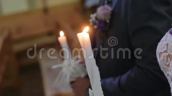 新婚夫妇在婚礼上举行的高黄蜡烛特写视频的预览图