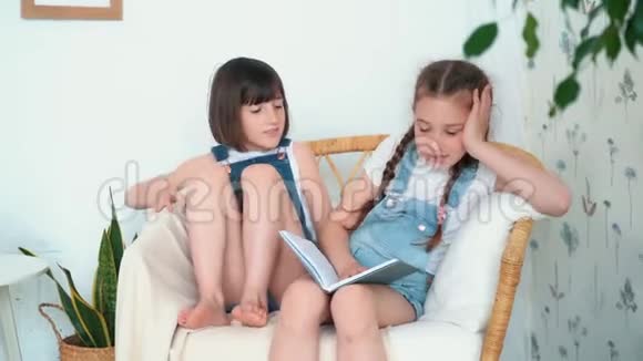两个可爱的小女孩坐在椅子上其中一个讲童话故事慢动作视频的预览图