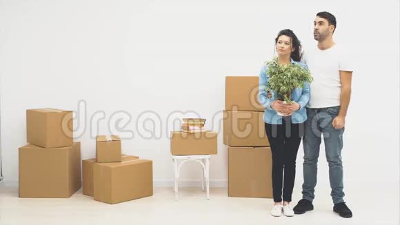 年轻夫妇一起搬到了一间新公寓妻子拿着一个花盆里面藏着公寓里的钥匙他们视频的预览图