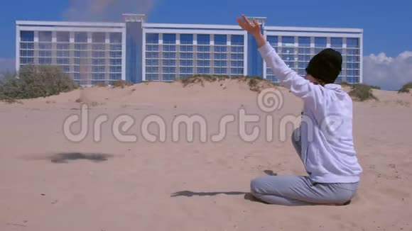 在阳光明媚的日子里海滩上的女旅行者在风中抛沙视频的预览图