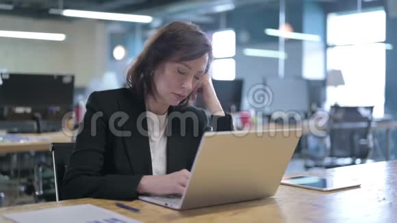 疲惫的中年女商人在办公室工作时快速打盹视频的预览图