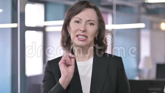 愤怒的中年女商人用手势回应失败的肖像视频的预览图
