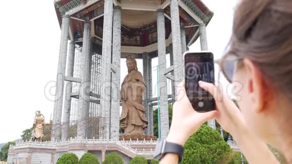 女用智能手机拍摄观音观音或佛寺观音雕像访问精神视频的预览图