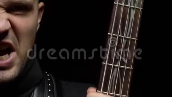 黑色背景下电吉他特写的男性脸和装饰板视频的预览图