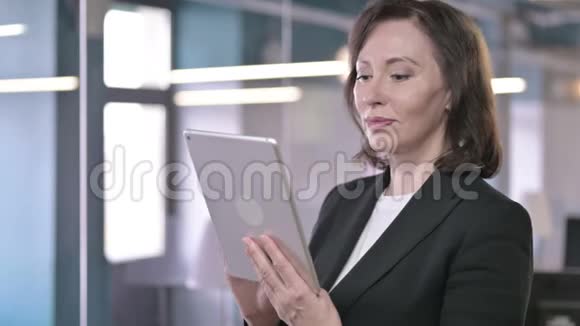正经中年女商人在平板电脑上工作的画像视频的预览图