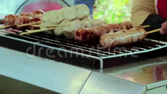猪肉球木棍用小香肠烤在电炉上在街上卖视频的预览图