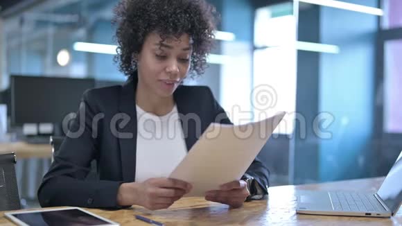 失望的非洲女商人阅读文件和面对失败的手势视频的预览图