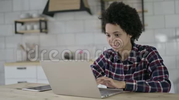 快乐的非洲裔美国妇女在笔记本电脑上得到惊喜视频的预览图