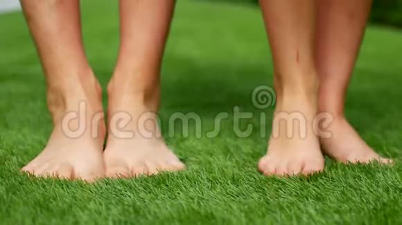 两个赤脚的人在绿草上2你的脚互相踩视频的预览图