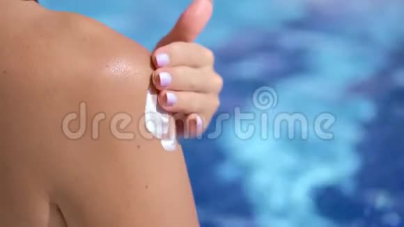 在日光浴期间贴身女性手在身体皮肤上涂抹防晒乳液视频的预览图