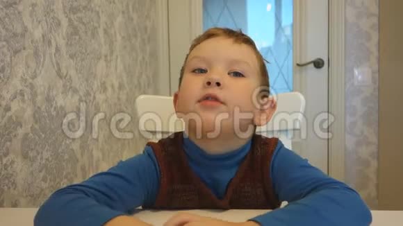 男孩在桌子旁说视频的预览图