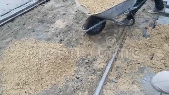 一个人用手推车运沙把手推车翻过来把沙子倒进一堆8s视频的预览图