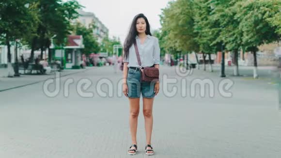 站在城市步行街看镜头的亚洲女士的时间流逝视频的预览图