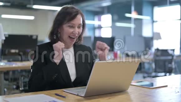 成功的中年女商人在工作中庆祝视频的预览图