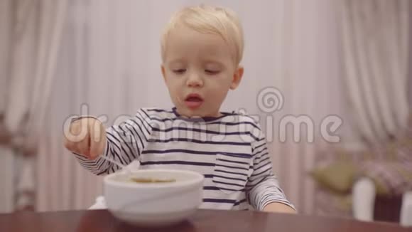 宝宝吃快乐的婴儿用勺子吃食物美丽的孩子在家吃早餐的肖像可爱视频的预览图
