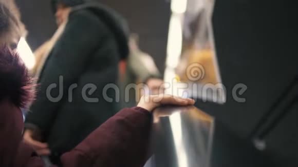 小女孩的手托在自动扶梯的扶手上视频的预览图