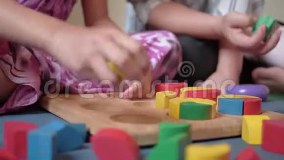 年轻的母亲和她的女儿在家里一起玩木玩具块视频的预览图
