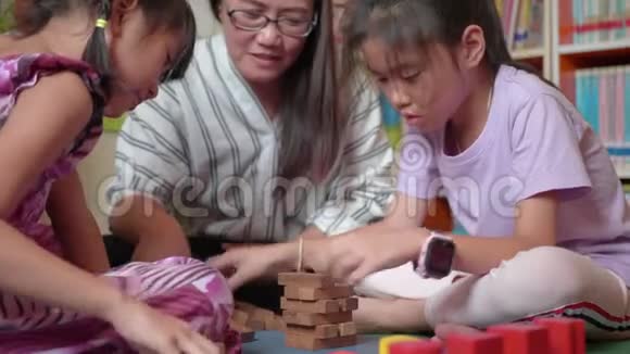 年轻的母亲和她的女儿试图建造木块塔视频的预览图