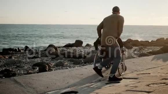 爱的男人在海上旋转着轮椅年轻的女人在海上欢乐视频的预览图