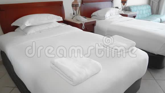 未被认出的成年高级妇女拿起一条白色毛巾躺在酒店房间的床上服务的概念视频的预览图