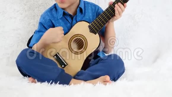 一个小男孩演奏一首儿童吉他唱一首歌音乐儿童教育幸福的概念视频的预览图