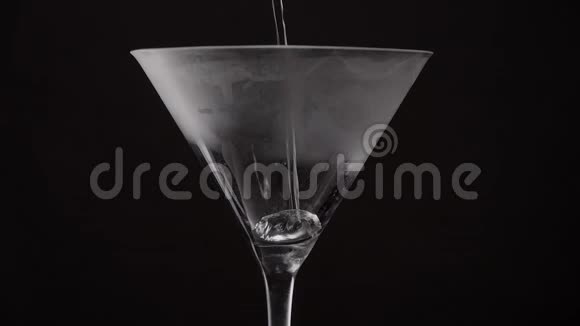 马丁尼饮料在黑色背景下将气泡倒入玻璃杯中视频的预览图