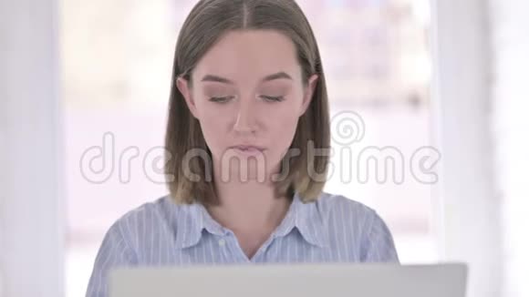 在笔记本电脑上进行视频聊天的年轻女性的肖像视频的预览图