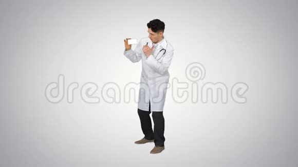 年轻的医生在梯度背景下展示新药和跳舞视频的预览图