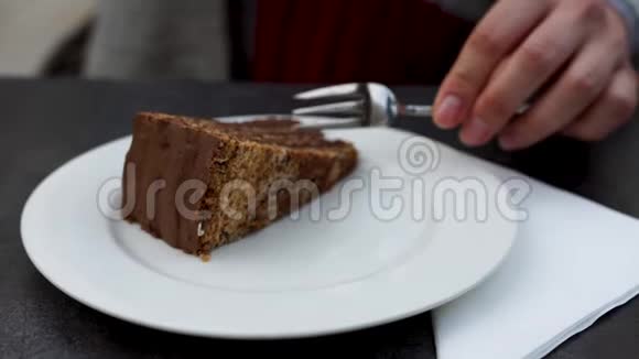 白色盘子上的巧克力蛋糕女孩用手拿一块蛋糕视频的预览图