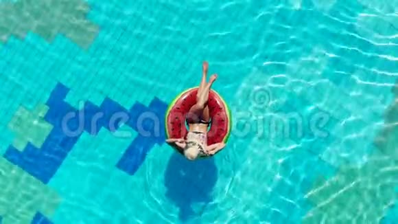 女人躺在游泳池里的橡胶圈上视频的预览图