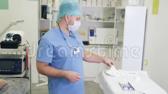 在硬化治疗前穿无菌衣服和口罩的医生戴上手套视频的预览图