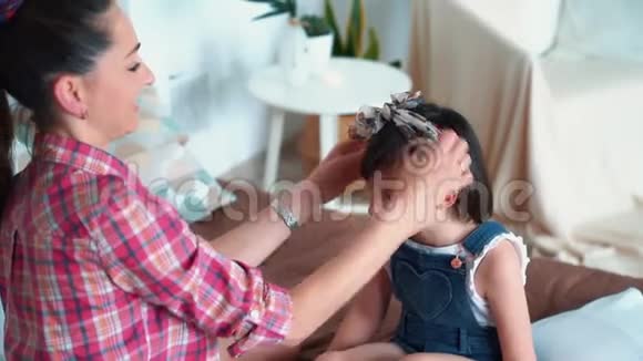 母亲把头戴在女儿的头发上吻她的鼻子动作缓慢视频的预览图