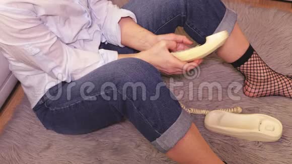 坐在地板上用复古电话拨号码的女人视频的预览图