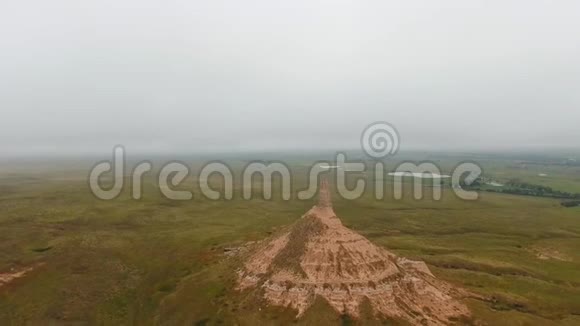 全景无人驾驶飞机在烟囱岩石国家历史遗址的背景下拍摄了田野湖泊和灰色天空的烟囱岩石视频的预览图