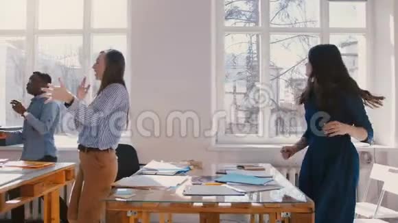 慢镜头快乐的多民族办公公司员工跳舞在轻盈的现代工作场所庆祝成功视频的预览图