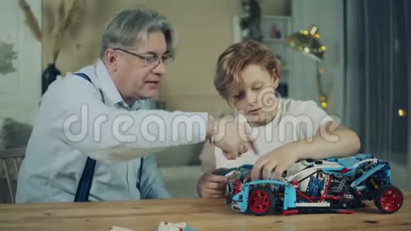 祖父和一个男孩正在组装玩具车视频的预览图