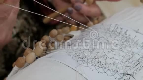 女人手用旧时尚织花边根据图案使用螺纹和筒管和针头手工特写镜头N视频的预览图