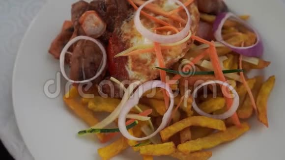 在盘子上盘炸土豆烤肉洋葱圈胡萝卜西葫芦胡椒视频的预览图