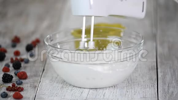 厨房搅拌器将蛋清搅拌至玻璃碗中的硬峰视频的预览图
