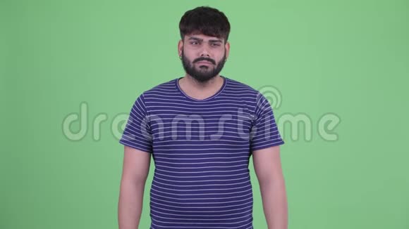 年轻的体重超重的长着胡须的印度男人看起来很伤心很哭视频的预览图