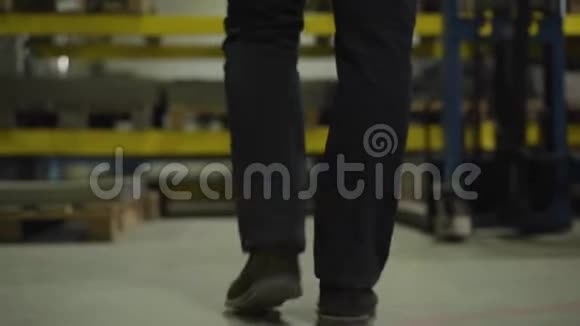 相机跟随男性腿来到钢金属薄板仓库并采取一项钢铁生产现场工人视频的预览图