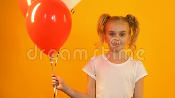 可爱的孩子拿着彩色气球对着镜头微笑b日问候视频的预览图
