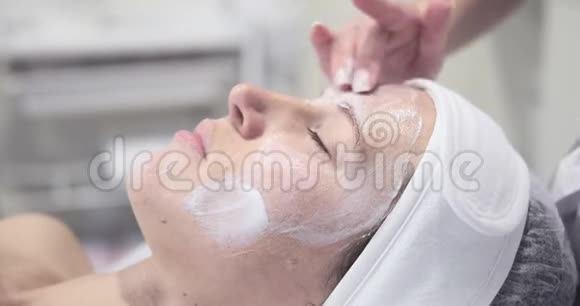 美容师给水疗中心的女人涂面霜视频的预览图