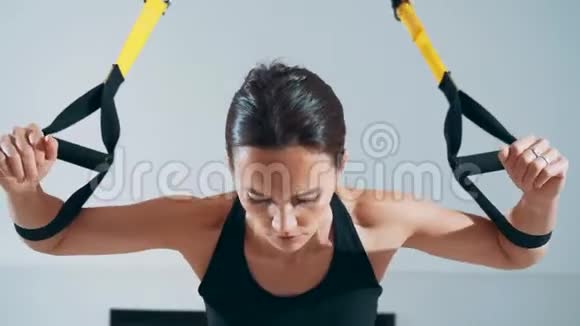 女孩在大厅里使用TRX循环锻炼胸部肌肉视频的预览图