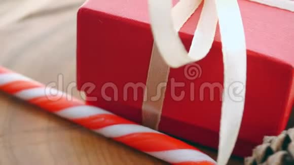 红色礼盒杉枝圣诞糖果花环金铃特写镜头运动回合视频的预览图