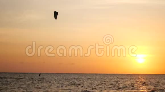 夕阳西下风筝冲浪者在大海上飞翔视频的预览图
