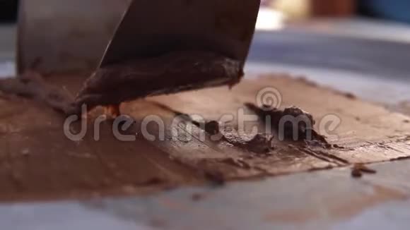在冷冻锅上做炒冰淇淋卷的过程加卷冰淇淋牛奶手工甜点巧克力特写视频的预览图
