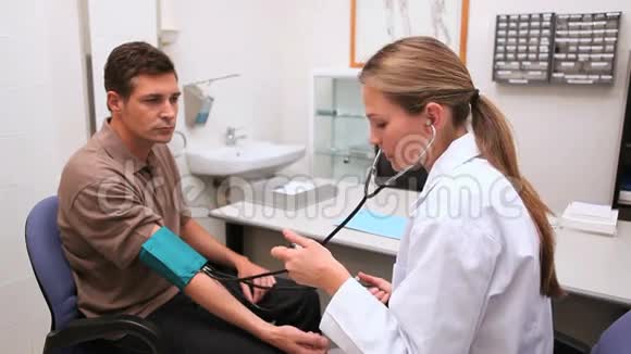 微笑的医生测量病人的血压视频的预览图